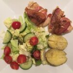 Bacon-wrapped chicken stuffed with  chive spread, baked potato with ghee, and a …