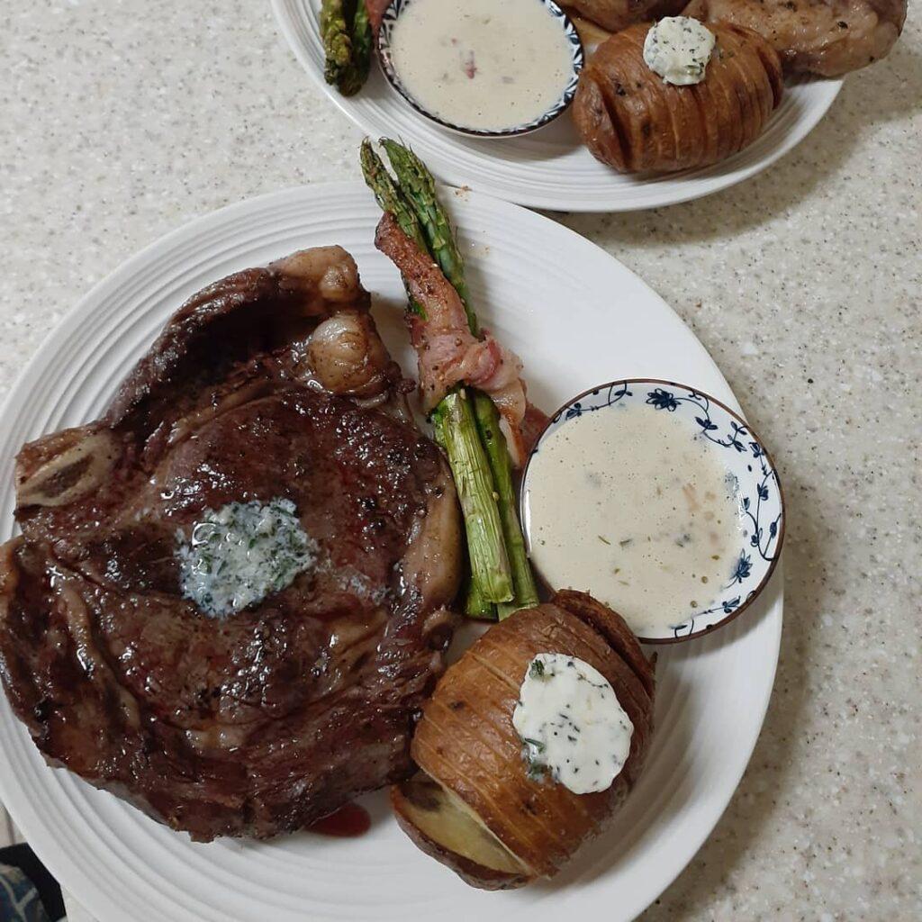 Sousvide bone in steak with bearnaise sauce, bacon tied asparagus, and store bou…